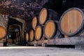 Wooden giant wine oak barrels stacked in rows. Aging, fermentation, store in old wine cellar. Concept sommelier trip