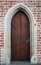Wooden gothic doors in a brick wall