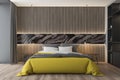 Wooden and gray bedroom interior, yellow bed Royalty Free Stock Photo