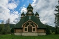 Wooden green chapel on a hill in the forest. Rustic chapel. Church against the forest and sky. Orthodox, christian monastery in su Royalty Free Stock Photo