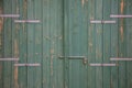 Wooden green aged door, rusty latch and padlock. Close up, details