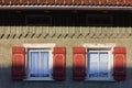 wooden green facade with red color shutter of bavarian farmhouse