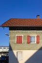 wooden green facade with red color shutter of bavarian farmhouse