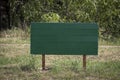 Wooden green plate on the posts for inscription. In the park, Surface for inscription