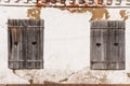 Wooden grey shutters with heart on old wall. Old wooden windows frame on stone wall Royalty Free Stock Photo