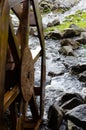 Wooden grist mill water wheel turning with the flow of water. Closeup Royalty Free Stock Photo