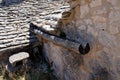 wooden gutter from a medieval tree trunk or branch from a very old farmhouse wall roof tiles house