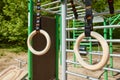 Wooden gymnastic rings hanging in a open air gym in a park, selective focus