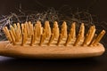 Wooden hairbrush with blonde hairs in it, black background