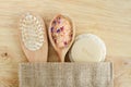 Wooden hairbrush, spoon with floral bath salts, soap bar and loofah sponge. Natural beauty treatment, skip-care or zero waste Royalty Free Stock Photo