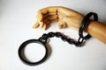 Wooden hand in handcuffs