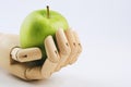 Wooden hand holding a granny smith apple on a white background Royalty Free Stock Photo