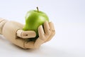 Wooden hand holding a granny smith apple on a white background Royalty Free Stock Photo