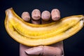 Wooden hand holding a split banana in half