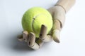 Wooden hand holding a tennis ball. Royalty Free Stock Photo