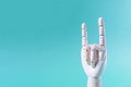 A wooden hand with raised index finger and little finger on a blue background of the space mine. Royalty Free Stock Photo