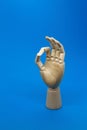 Wooden hand shows the ok sign on blue background. Positive concept Royalty Free Stock Photo