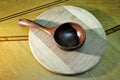 Wooden handmade brown spoon round bamboo plate natural background