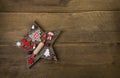 Wooden handmade carved star with red and white christmas decoration on an old background of wood. Royalty Free Stock Photo