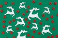 Wooden handmade Christmas decorations white Deers and red Stars with a pattern on a green isolated background. Flat lay, top view. Royalty Free Stock Photo