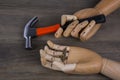 Wooden hands holding hammers and nails