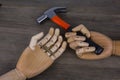 Wooden hands holding hammers and nails