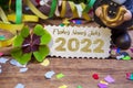 Wooden hang tag and slate with four leaf clover and sparklers with the german words for happy new year - frohes neues jahr 2022 on Royalty Free Stock Photo