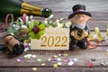 Wooden hang tag and slate with four leaf clover and sparklers with happy new year 2022 on wooden weathered background Royalty Free Stock Photo