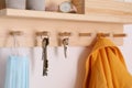 Wooden hanger for keys with different stuff on white wall, closeup Royalty Free Stock Photo