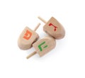 Wooden Hanukkah traditional dreidels with letters Gimel, Pe and He on white background, top view Royalty Free Stock Photo