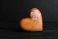 Wooden heart with adhesive plasters in darkness Royalty Free Stock Photo