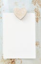 Wooden heart, blank sheet of paper and rough background