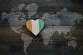 wooden heart with national flag of cote divoire near world map on the wooden background