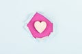 Wooden heart on a pink and light blue background, torn paper, holiday background, valentines day, friendship, love and charity