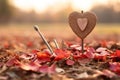 a wooden heart is placed in the middle of a field of fallen leaves Royalty Free Stock Photo