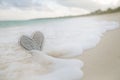 Wooden heart in sea waves, live action