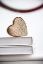 Wooden heart shape on a open book. Love reading concept close up. Royalty Free Stock Photo