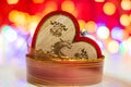 Wooden heart shaped Christmas ornament surrounded by a colorful garland. Christmas decorations on blurred lights background Royalty Free Stock Photo