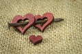 Wooden hearts with rusted nail on jute surface Royalty Free Stock Photo