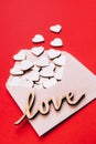 Wooden hearts in an open craft envelope, word love