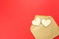 Wooden hearts spill out of an open envelope on a red background. Valentine`s Day, love letter, declaration of love, acquaintance. Royalty Free Stock Photo