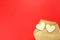 Wooden hearts spill out of an open envelope on a red background. Valentine`s Day, love letter, declaration of love, acquaintance. Royalty Free Stock Photo