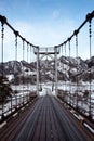 Wooden hinged bridge over the river. Winter day. The road to the mountains. Altai mountains, Russia Royalty Free Stock Photo