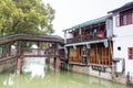 Wooden historic buildings at the bank of canal river in Zhujiajiao in a rainy day, an ancient water town in Shanghai, built during