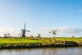 Wooden hollow post mill and a small metal polder mill next to ea Royalty Free Stock Photo