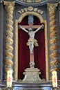 Wooden holy cross or crucifix with Jesus figure carved in wood in a baroque altar in a church