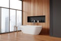 Wooden home bathroom interior with tub, built-in shelf and bathing accessories Royalty Free Stock Photo