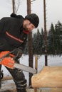 Wooden home building, chainsaw blade cutting log of wood.