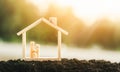 Wooden home with happy family of wooden doll is placed inside on nature bokeh. The saving money for house or real estate owner in Royalty Free Stock Photo