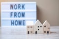 Wooden Home model and lightbox with text WORK FROM HOME on table. Coronavirus, Covid-19, Quarantines and Social Distancing concept